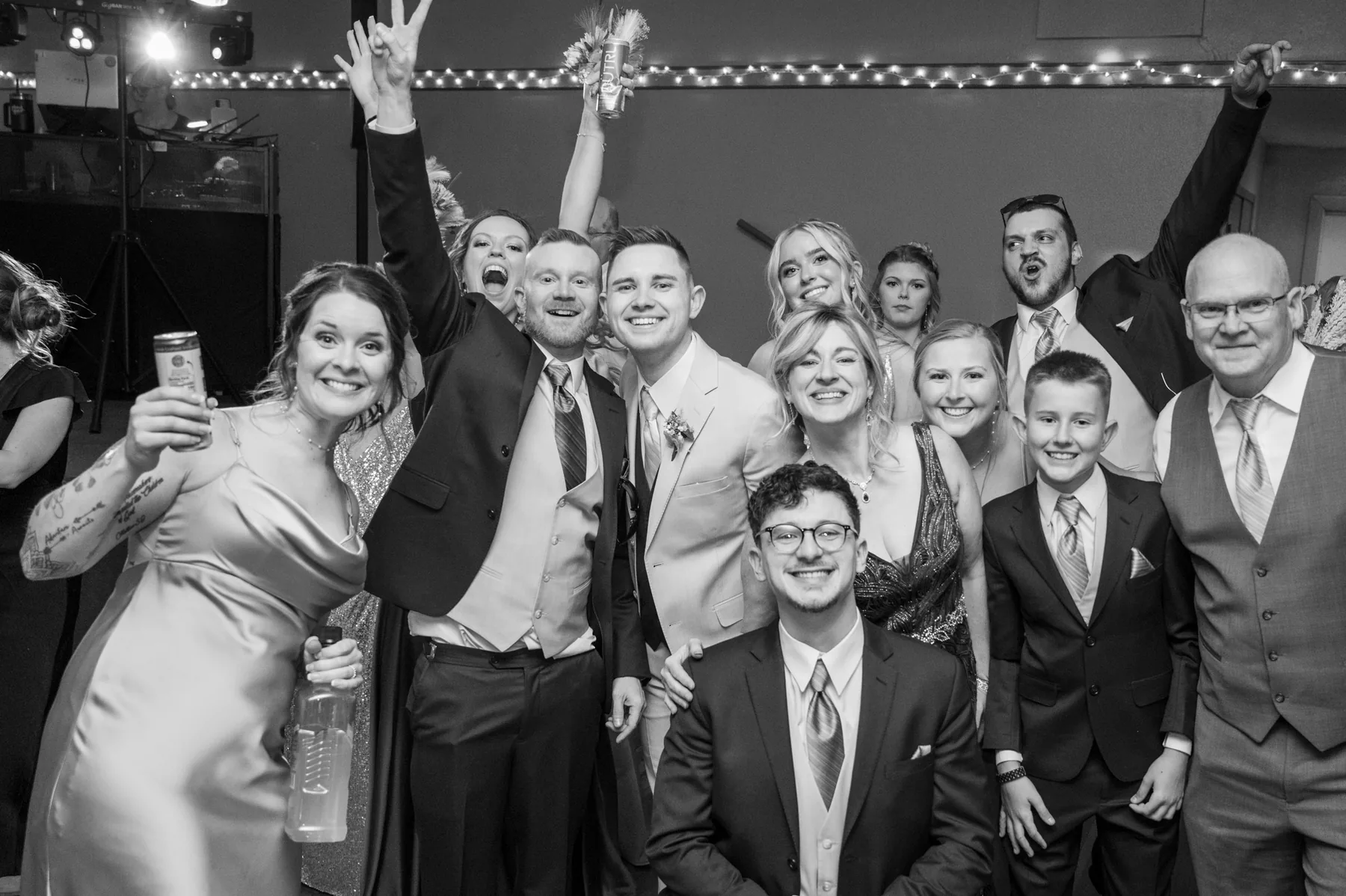 The whole reception gathered together, drinks raised and arms in the air