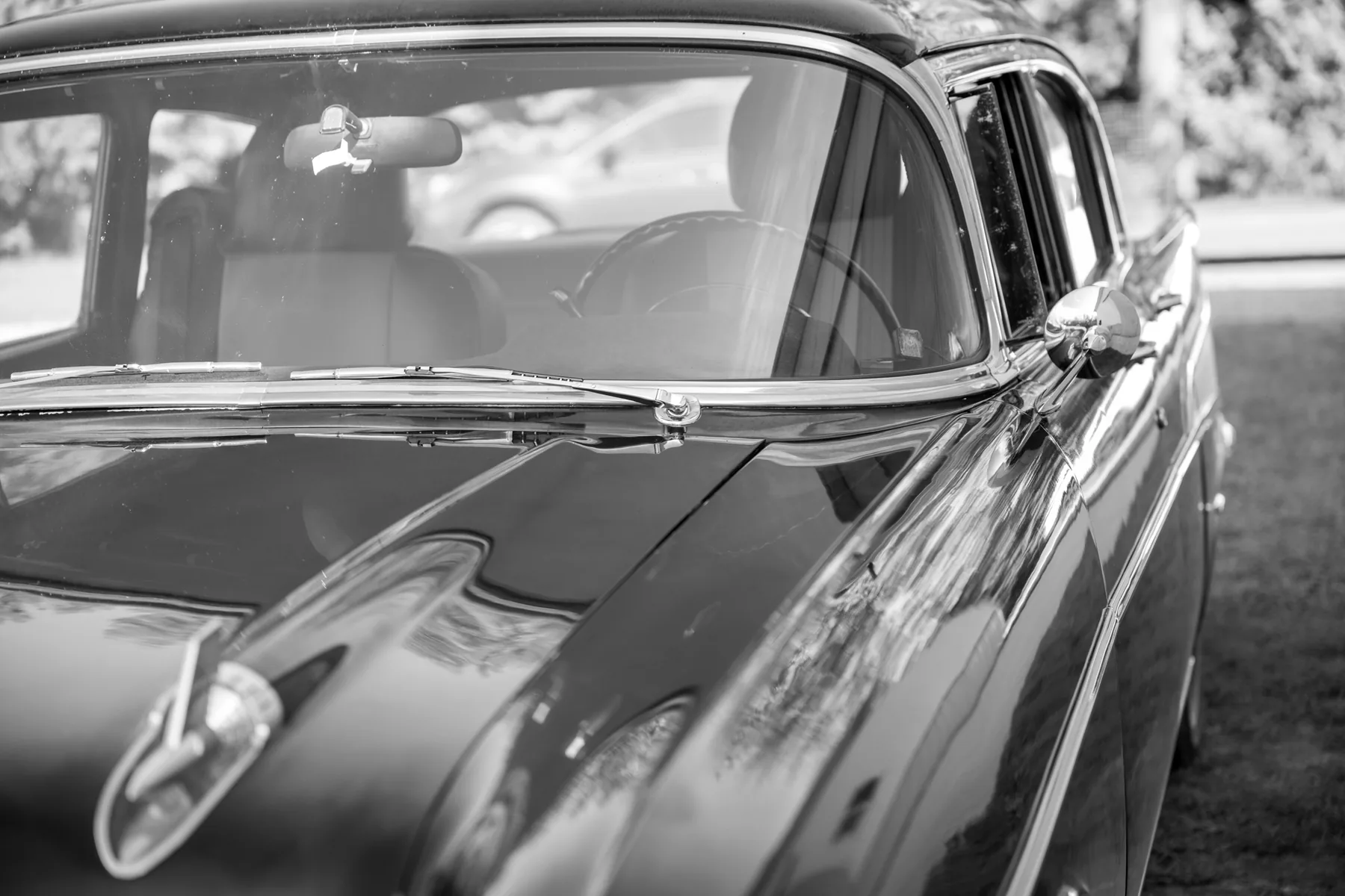 Pine trees reflected in the chrome and paint of the family's Chevy Bel Air
