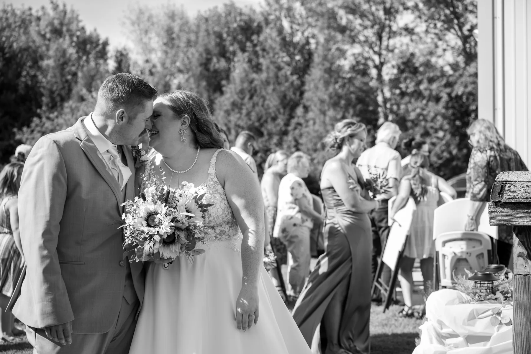 Michael leaning his forehead to Kelsey's in the first minutes after the ceremony, guests moving past in every direction