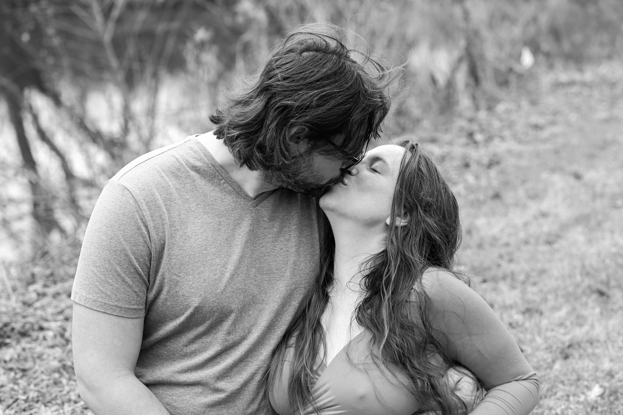Maternity photography — couple sharing a kiss outdoors — Amy Minikus Photo + Film